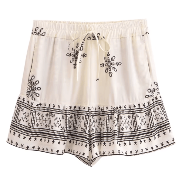 Ivory Sands white boho border print high waist drawstring shorts with pockets made from breathable cotton rayon featuring an ivory and black geometric print with a feminine ruffle hem for beach vacations and casual summer outfits.