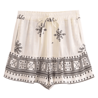 Ivory Sands white boho border print high waist drawstring shorts with pockets made from breathable cotton rayon featuring an ivory and black geometric print with a feminine ruffle hem for beach vacations and casual summer outfits.