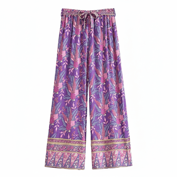 Wild Orchid boho wide leg pants with functional side pockets, a high waist drawstring waistband, lightweight rayon fabric, and a flowy purple floral palazzo silhouette with a vibrant botanical print.