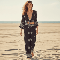 Woman wearing a boho black print kimono and wide leg pants set with a tie-front top, flowing bell sleeves, relaxed fit, and lightweight bohemian style.