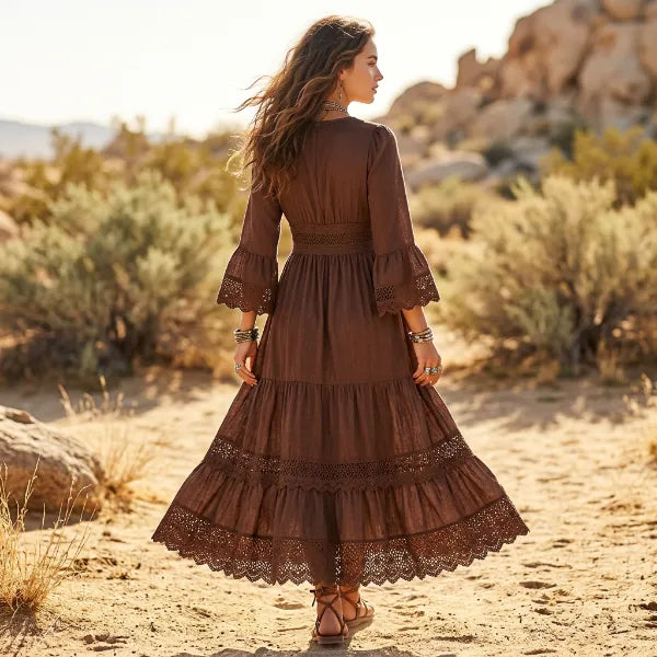 Back view of chocolate-brown long sleeve maxi dress featuring a flowing A-line silhouette and tiered lace-trimmed skirt.