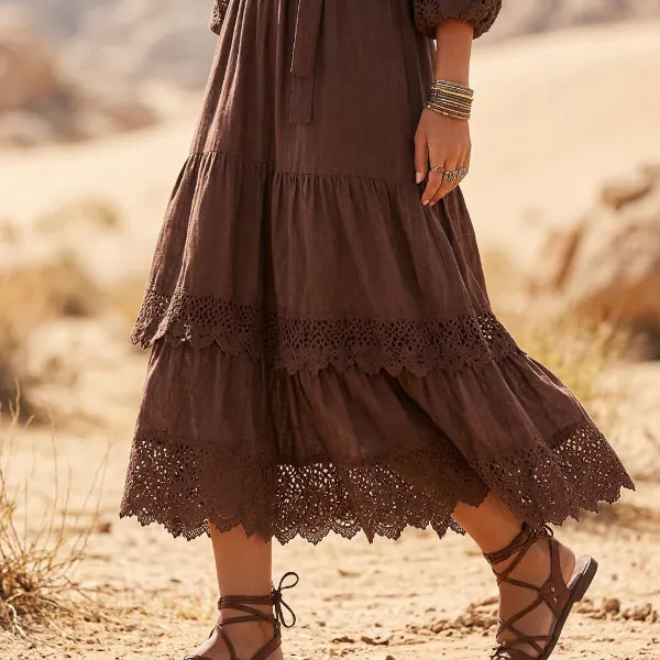 Vintage-inspired brown maxi dress with romantic lace ruffle detailing, long gathered sleeves, and flowing tiered hem.