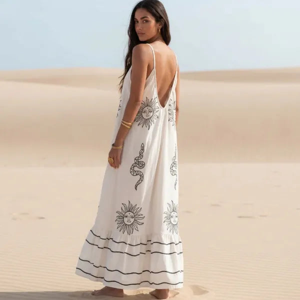 Back of a white boho floral backless maxi sundress with black print, spaghetti straps, V-neck and flowy A-line skirt