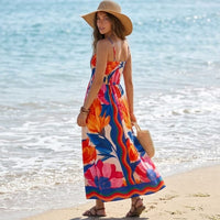 Back view of a multicolor floral maxi dress showing a stretchy smocked back, thin spaghetti straps, and a flowing full-length skirt.