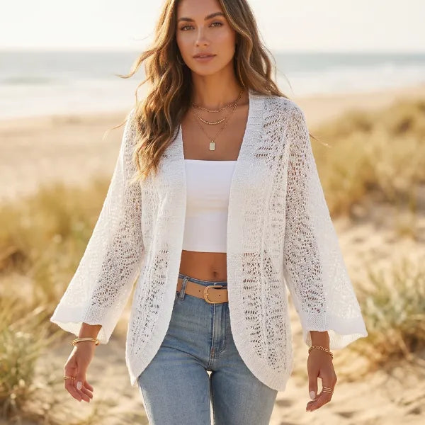 Women’s white boho crochet cardigan with batwing sleeves, open-knit detailing, and relaxed fit styled with jeans.