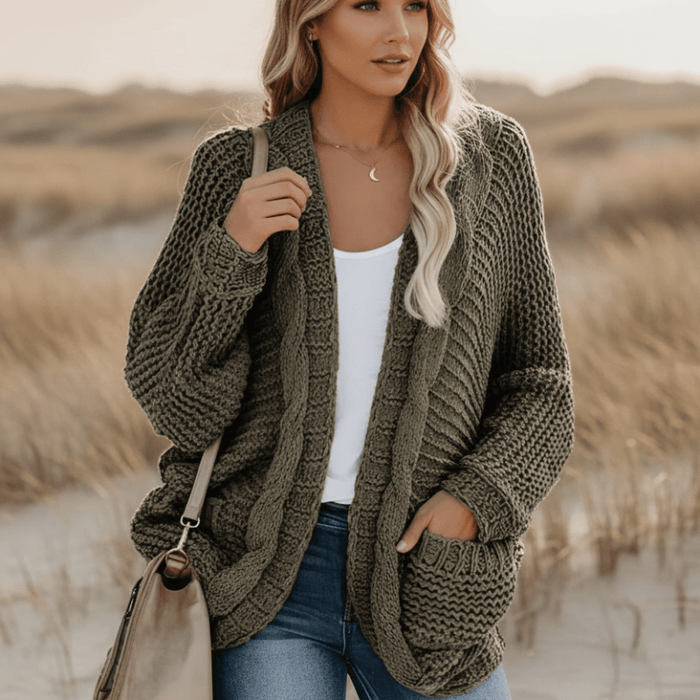 Woman wearing an army green boho oversized knit cardigan with open front, batwing sleeves, textured knit and large patch pockets