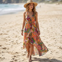 Woman wearing a red floral halter maxi dress with a plunging V-neckline, gathered waist, and flowing high-low hem on the beach.
