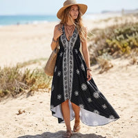 Black floral halter maxi dress featuring a vintage-inspired print, open back, and flowing high-low silhouette.