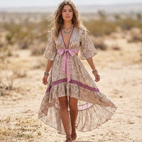 Woman wearing a leopard print high-low boho dress with pink waist bow, deep V-neckline, short flutter sleeves, and flowing ruffled skirt.