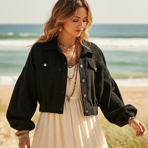 Woman wearing a black boho cropped corduroy jacket with lantern sleeves and button front