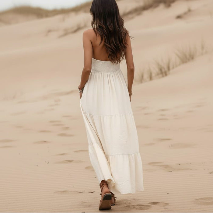 Back of white boho halter open back maxi dress with tiered flowy skirt and shell details