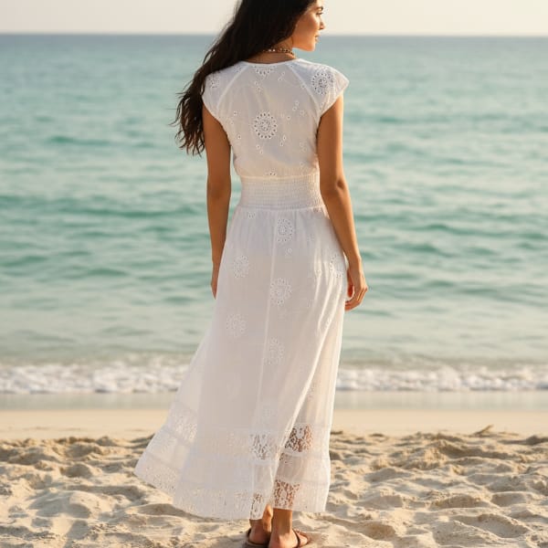 Back of woman wearing a white boho maxi dress, a-line silhouette and v-neckline.