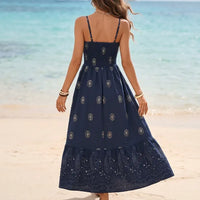 Back view of navy blue bohemian maxi sundress featuring thin straps, flowing skirt, and decorative paisley print.