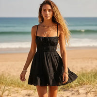 Woman wearing black boho backless tiered mini dress with tie straps