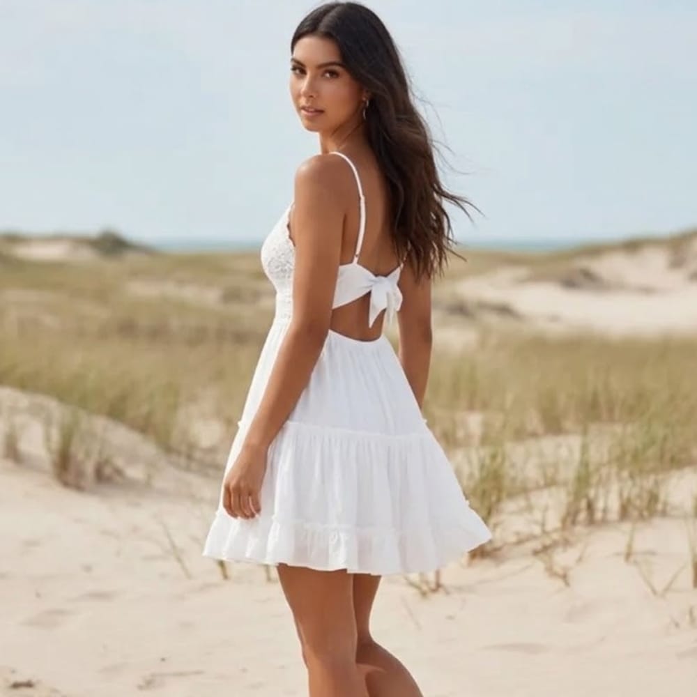 White open back babydoll mini dress with lace bodice and tiered ruffle skirt