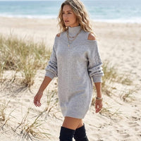 Woman wearing a gray cable knit mini sweater dress with cold shoulder cutouts, mock neckline, and long lantern sleeves.