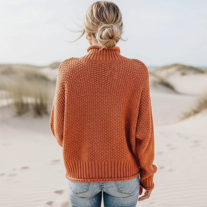 Back of a woman wearing a burnt orange boho mock neck knit pullover sweater with textured knit, long sleeves and relaxed fit