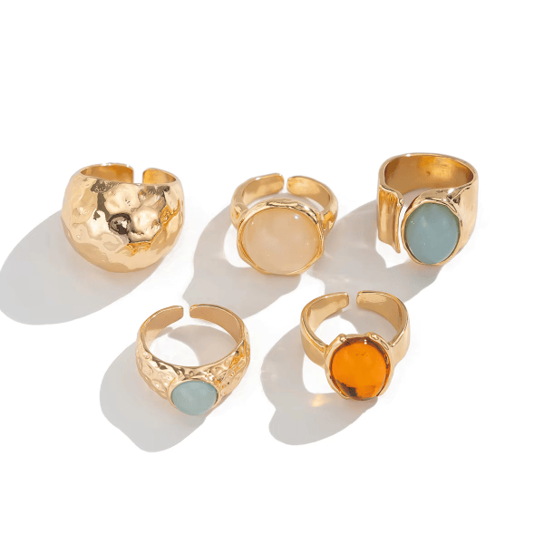 Close-up of adjustable vintage gold-tone statement rings with hammered finishes and decorative oval and round accents.