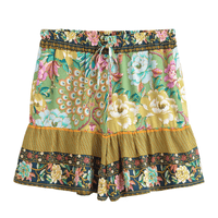 Green boho floral high waist drawstring shorts with pockets in breathable cotton rayon featuring a colorful peacock-inspired print for resort wear and beach outfits.