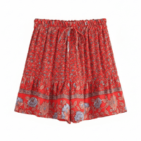 Scarlet Blossom boho floral shorts with a high waist drawstring waistband, lightweight rayon fabric, relaxed flowy fit, feminine ruffle hem, and a vintage-inspired floral border in vibrant scarlet red.