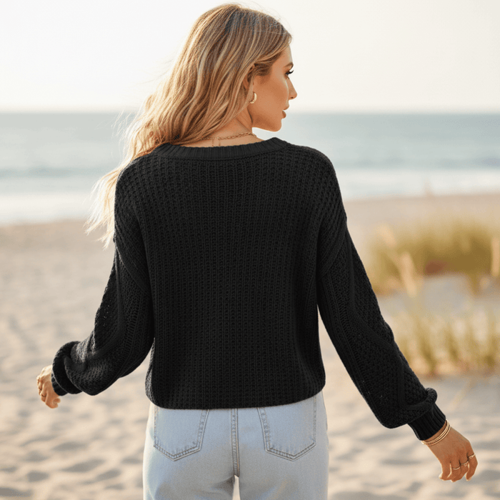 Back of woman wearing a black women’s boho cable knit sweater with a textured cotton-acrylic knit, long sleeves, and relaxed pullover fit