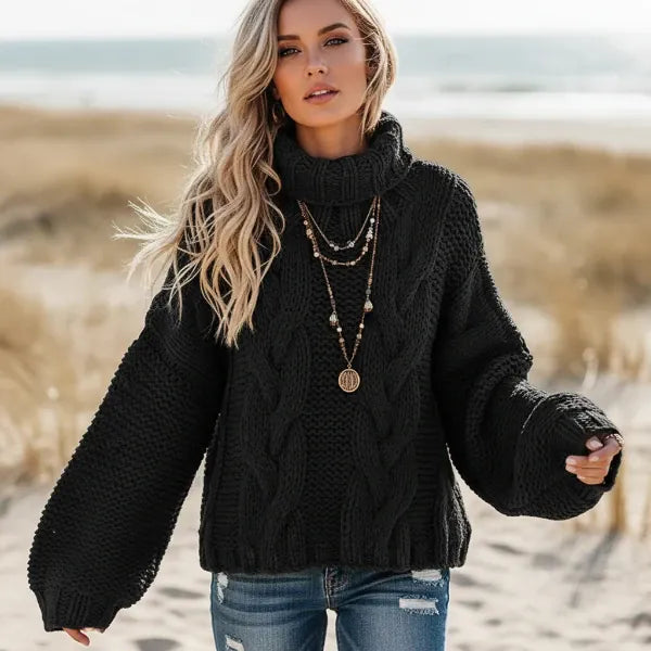 Woman wearing black boho chunky knit turtleneck sweater with wide sleeves