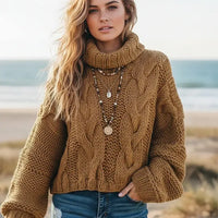 Woman wearing camel brown boho chunky knit turtleneck sweater with wide sleeves