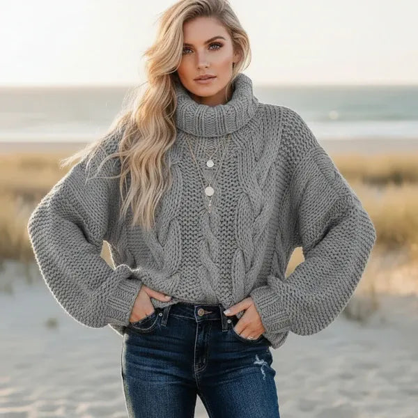 Woman wearing gray boho chunky knit turtleneck sweater with wide sleeves