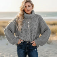 Woman wearing gray boho chunky knit turtleneck sweater with wide sleeves