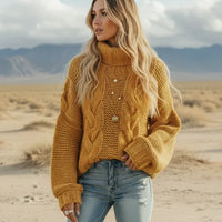 Woman wearing mustard yellow boho chunky knit turtleneck sweater with wide sleeves