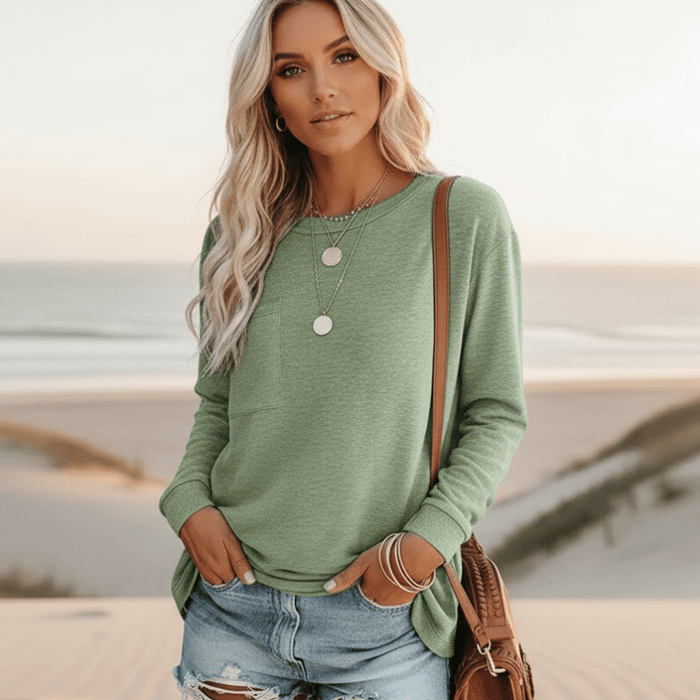Woman wearing sage green boho long sleeve top with chest pocket, round neckline and relaxed fit