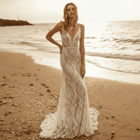 Front of a bride wearing a white lace A-line wedding dress with a sweetheart neckline, long lace sleeves, floral lace detailing, zipper back, and court train.