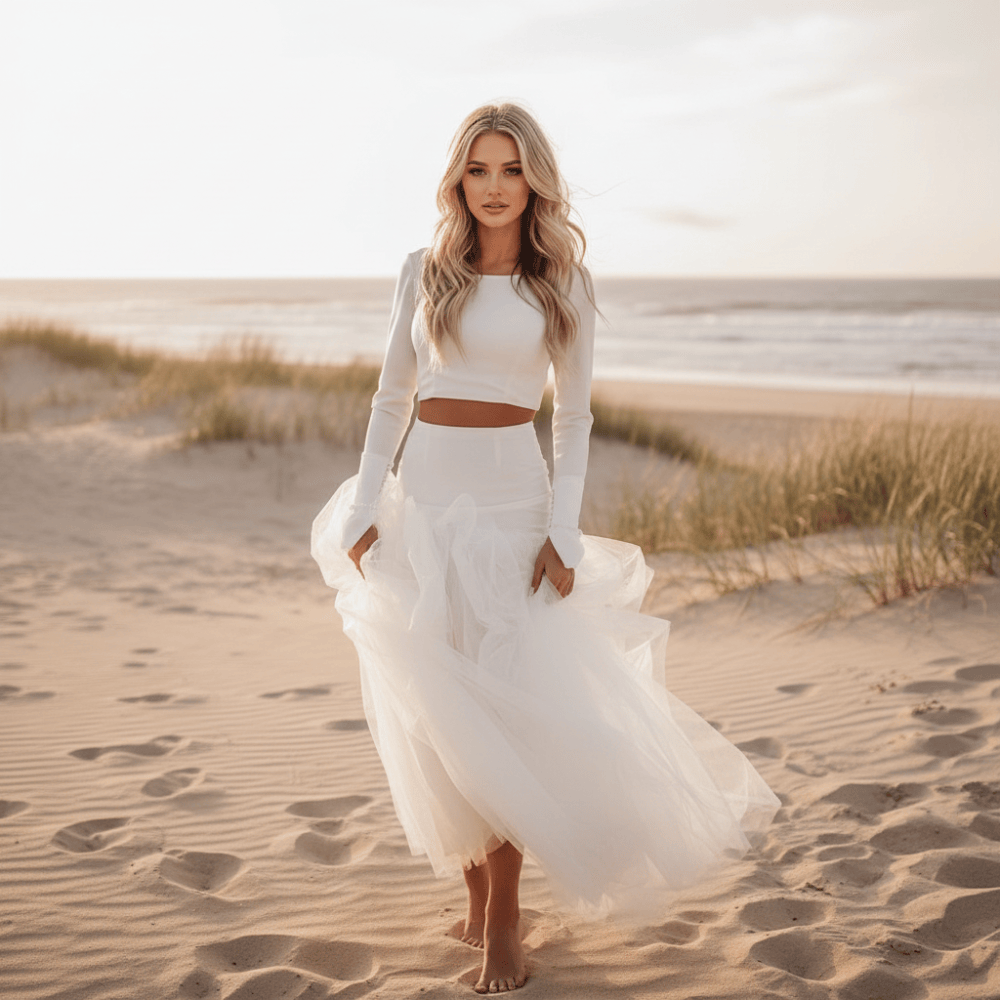 Bride wearing a two-piece ivory boho wedding dress with a high neckline, full-length sleeves, ruched detailing, A-line silhouette and flowing court train.