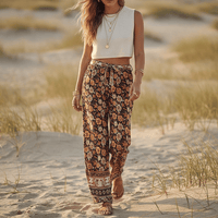 Woman wearing Autumn Bloom boho wide leg pants with functional side pockets, a high waist drawstring waistband, lightweight rayon fabric, and a flowy floral palazzo silhouette.