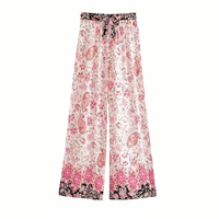 Blush Blossom boho wide leg pants with functional side pockets, a high waist drawstring waistband, lightweight rayon fabric, and a flowy floral palazzo silhouette featuring a pink floral and paisley print.