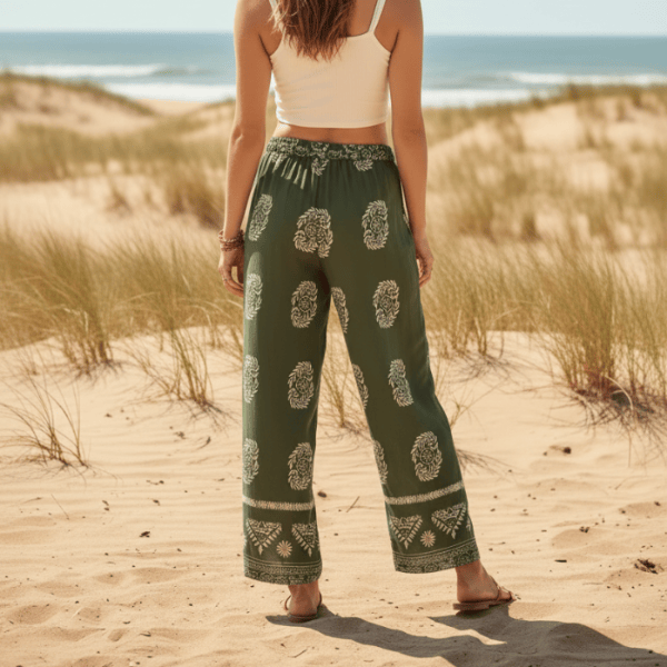 Woman showing the back of her Boho Olive Meadow wide leg palazzo pants in olive green with ivory boho print and relaxed rayon fabric.