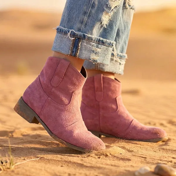 Pink boho western ankle booties with distressed-look texture, pointed toes, and relaxed above-ankle silhouette.