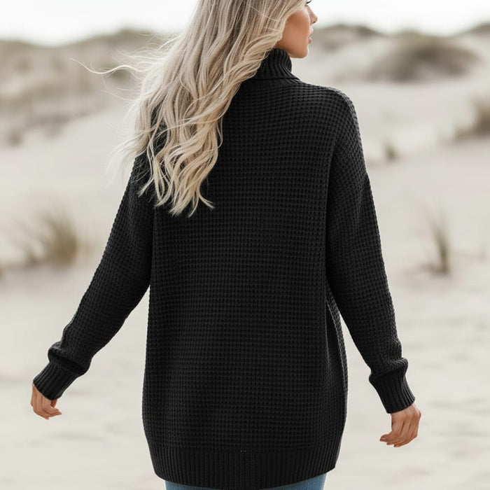 Back of a woman wearing a black boho long knit cardigan with open front, textured stitch, long sleeves and front patch pockets